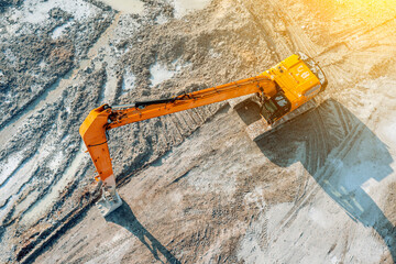 An excavator at a construction site plans the ground before work on the foundation