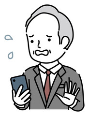 スマホを操作する焦っているシニア男性ビジネスパーソン