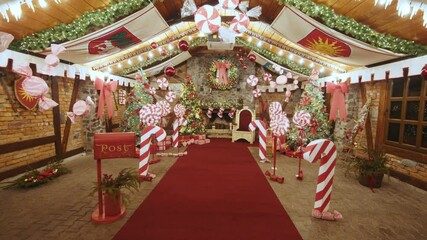 Luxurious red chair Santa Claus throne surrounded by multiple gift boxes. Decorative mailbox Santa Claus workshop, wrapped gifts presents boxes on holiday eve in night on xmas background