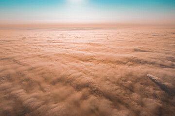 Sunset cloudy sky from aerial view. Airplane view above clouds. Dusty clouds over city. Dust. Pollution. Sands. Sand hurricane. Dangerous. Fireplace