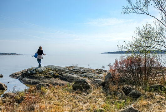 Woman on a shore near lake Värnen, Sweden