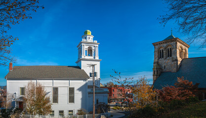 Plymouth downtown skylines and religious building structures over the autumn forest.