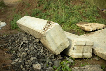 Fragments of concrete structure lying on the ground. The structure of the coarse material is gray. Construction in Russia.