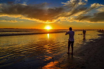 Fototapeta na wymiar Dramatic and beautiful setting sun at sunset beach