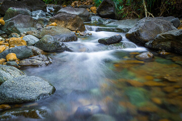 slow shutter speed of soft water and rocks river in jungle 