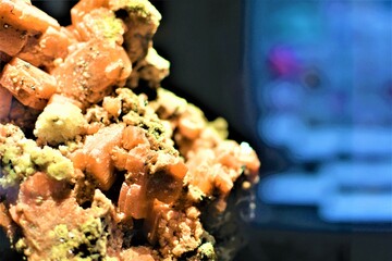 Orange hued minerals on display in a museum. Geological rocks volcanic stone background concept. Copy space