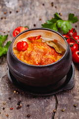 Crock pot pork roast with vegetables and cheese on wooden rustic table. Close up