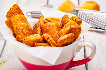 Cheese cookies in cup on wooden rustic table. Close up