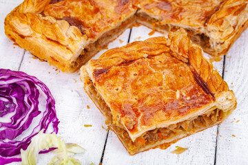 Homemade cabbage pie on wooden rustic background. Close up
