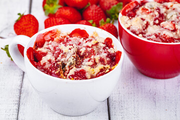 Strawberry crumble in cup on wooden rustic table. Close up