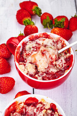 Strawberry crumble in cup on wooden rustic table. Close up