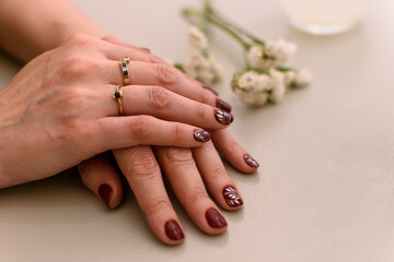Manos de mujer con anillos y uñas pintadas artísticamente