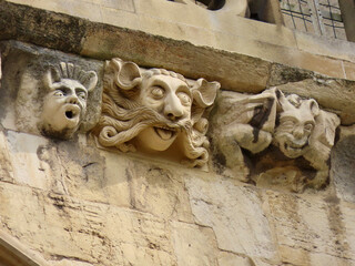 Face decorations in various stages of decay and restoration on exterior of gothic York Minster cathedral, England, UK. Close up