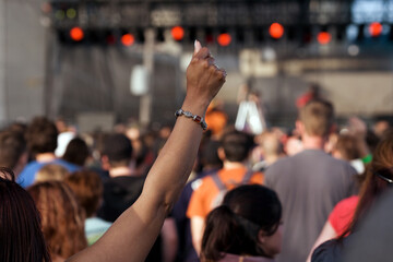 woman at concert raises her arm in the air