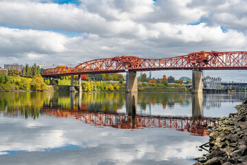 Broadway drawbridge over the Willamette River in Portland with water reflection and autumn trees