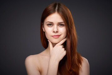 Fototapeta premium pretty red-haired woman naked shoulders posing dark background