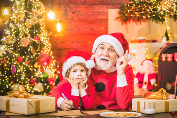 Obraz na płótnie Canvas Santa helper grandson and grandfather Write Letter to Santa Claus.