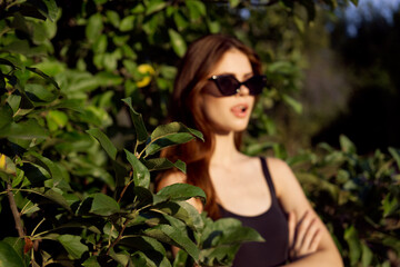 pretty woman in sunglasses in summer outdoors green leaves