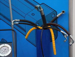 A set of eight black high pressure hoses on a blue exhibition stand