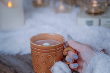ココアの入ったマグカップを持つ女性の手