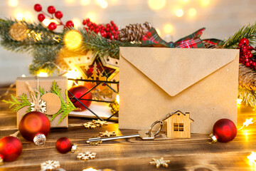 Key to the house with a keychain on a table with a Christmas decor. A gift for New Year, Christmas....