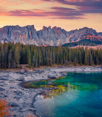 Frozen Karersee lake, Province of Bolzano - South Tyrol. Mystical autumn sunrise in Dolomite Alps. Majestic outdoor scene of Itale, Europe. Beauty of nature concept background..