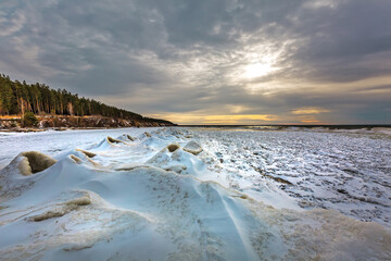 Winter landscape with a river covered with snow and ice hummocks. Western Siberia