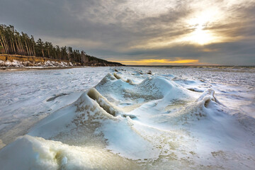 Winter landscape with a river covered with snow and ice hummocks. Western Siberia