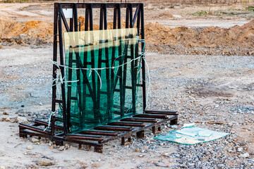 New sealed glass units at building site against the backdrop of a sunset sky. Storage and...