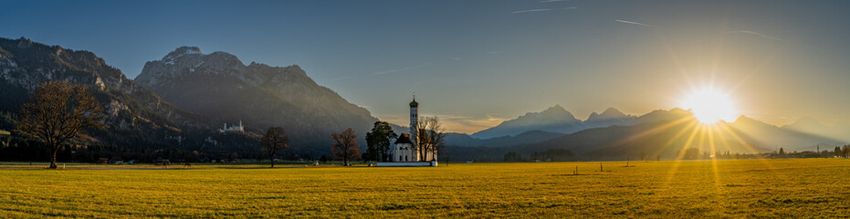 Wallfahrtskirche St. Coloman und Schloss Neuschwanstein im Sonnenuntergangs Panorama