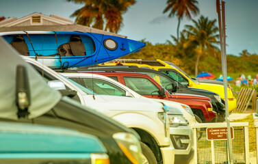 Colorful cars parked in a row along the sea.