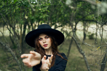 woman in a black hat gesturing with her hands witch magic fantasy