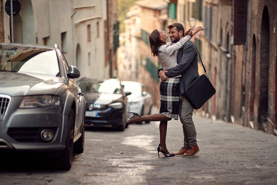 A young elegant couple in love is in hug while walking the city. Walk, rain, city, relationship