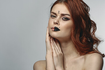 red-haired woman naked shoulders zodiac sign on face gemini
