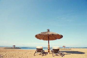 Vacation concept. Two sunloungers and umbrella on sand sea beach.