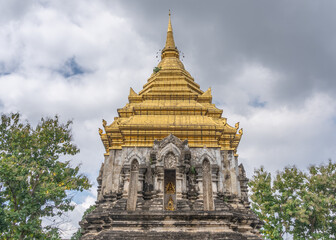 Low angle landscape view of beautiful golden stupa at ancient landmark Wat Chiang Man, the oldest buddhist temple in Chiang Mai, Thailand - obrazy, fototapety, plakaty
