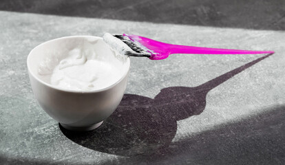 bowl with hair dye and brush for dyeing on a light background close-up hair care hair mask top view