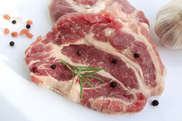 Sliced raw pork meat with herbs on white background. Top view