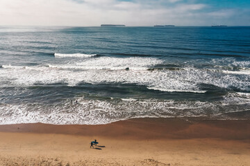 Fototapeta na wymiar Beach Shoreline Surfers Walking