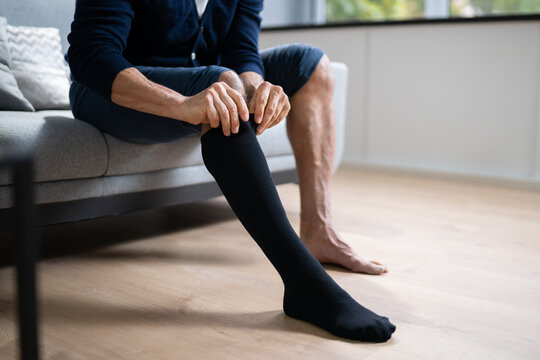 Man Putting On Medical Compression Stockings