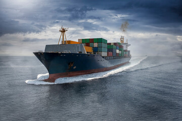 Aerial view of a big cargo container ship traveling over the ocean with fog and clouds