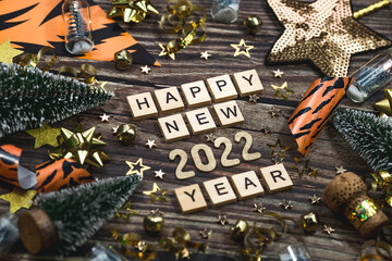 Banner. A symbol from the number 2022 with golden balls, stars, sequins and tiger print on a wooden background. The concept of celebrating a Happy New Year and Christmas.