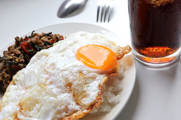 Rice topped with fried egg served with stir fried minced beef with basil leaves (Pad Ka Prao), Thai food stir fried holy basil with minced beef.