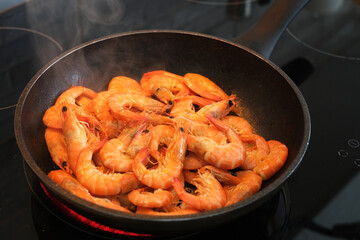 the cook fries shrimps in garlic sauce in a frying pan close-up. asian shrimp in sauce close-up