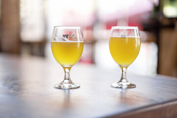 Bottom view of wooden table with alcohol cocktails at cafe. Concept of holiday, party and event. Modern interior. Sunny day. No people