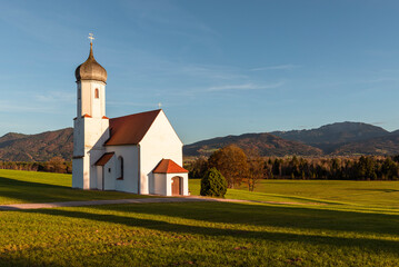 Die Kapelle St. Johann oberhalb des Loisachtals, dem Kochelsee und den herbstlichen bayrischen...