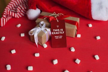 christmas gift boxes with red and white ribbons and marshmallows on red background