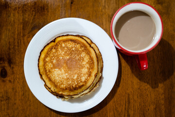 Top view of pancakes on white plate and hot choco