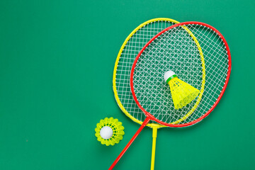 Two shuttlecock and badminton racket. on a green background.