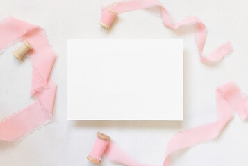 Blank Card on table with pink flowers and ribbons